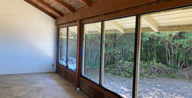 unfurnished sunroom featuring lofted ceiling with beams and wooden ceiling