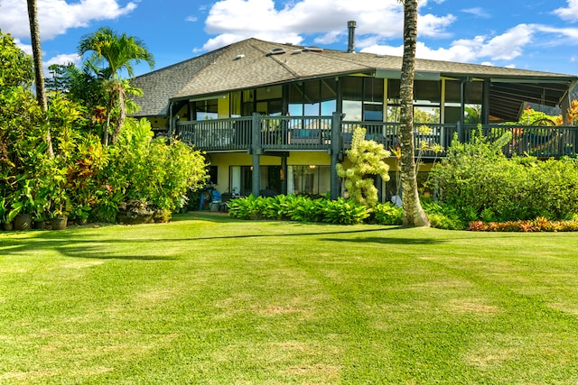 rear view of property with a sunroom and a yard