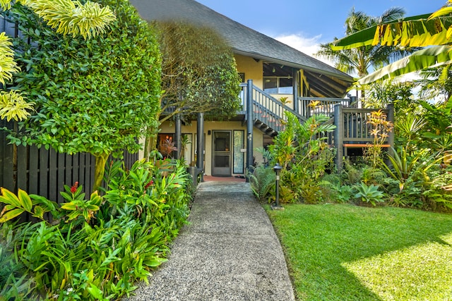 view of exterior entry featuring a lawn