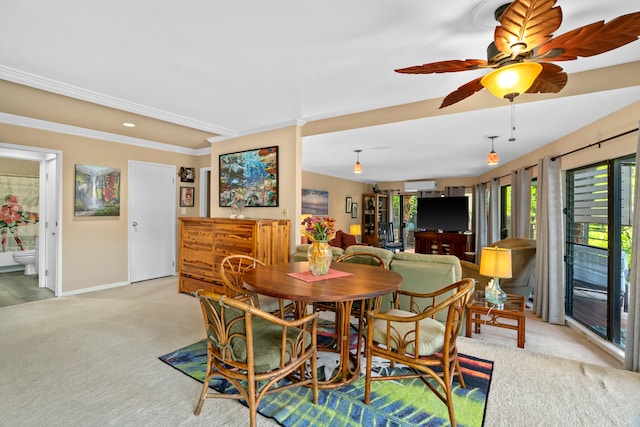 carpeted dining space with crown molding and ceiling fan