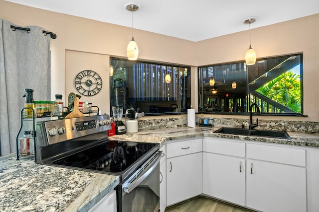 kitchen featuring pendant lighting, white cabinetry, stainless steel electric range oven, and sink