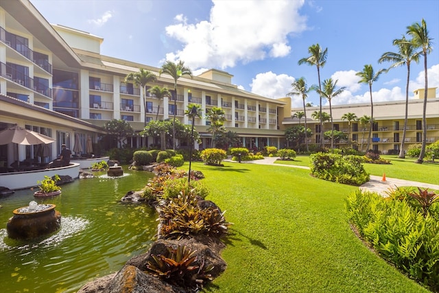 view of property's community featuring a lawn and a water view