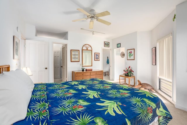 carpeted bedroom with connected bathroom, track lighting, and ceiling fan