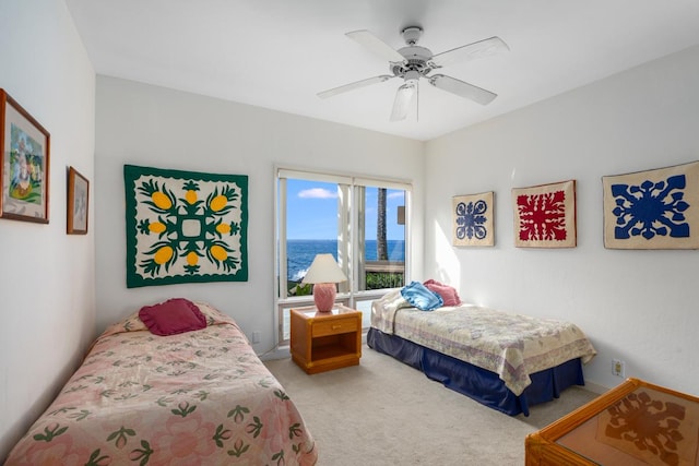 bedroom with light carpet, a water view, and ceiling fan