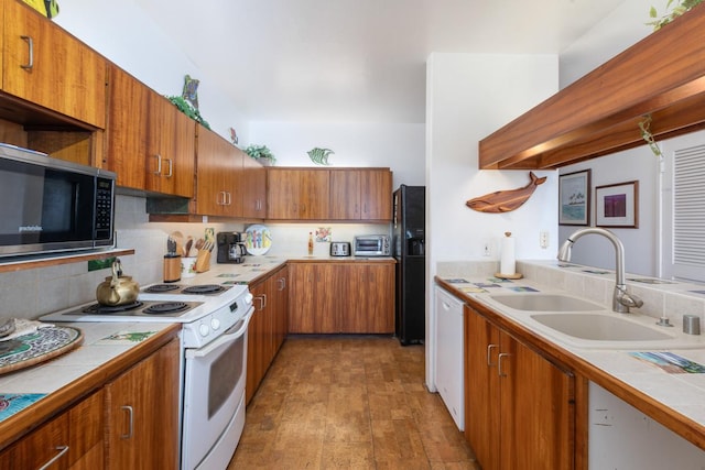 kitchen with white appliances, backsplash, sink, dark hardwood / wood-style floors, and tile counters