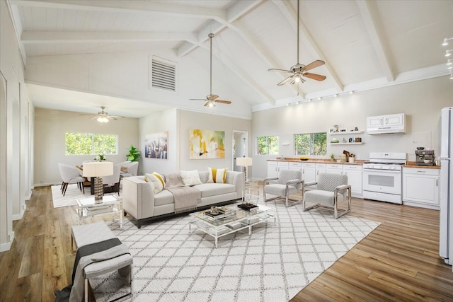 living room with beamed ceiling, high vaulted ceiling, and light hardwood / wood-style floors