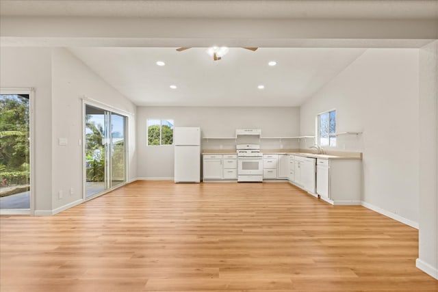 kitchen featuring plenty of natural light, white appliances, and light hardwood / wood-style flooring