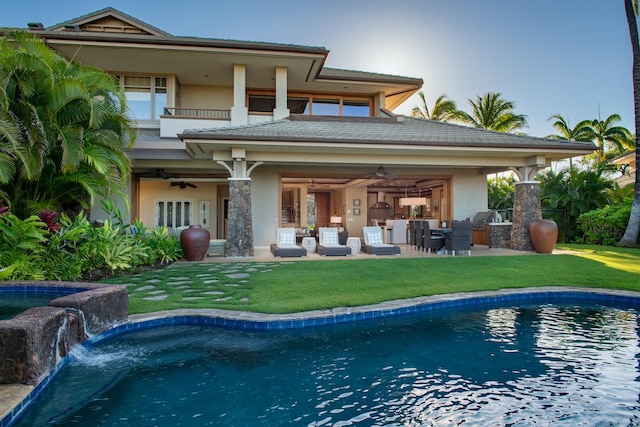 back of house featuring ceiling fan, a balcony, pool water feature, and an outdoor kitchen