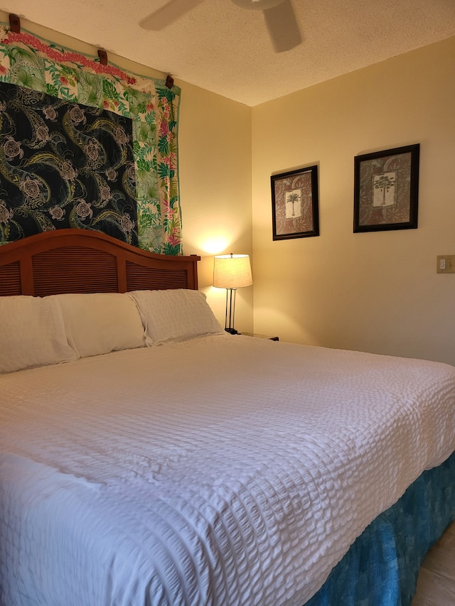 bedroom featuring ceiling fan and a textured ceiling