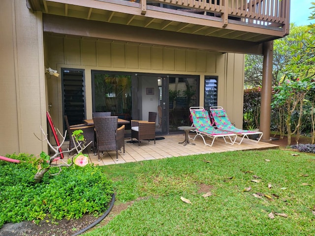 wooden deck with a yard and a patio