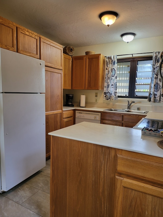 kitchen featuring sink, light tile patterned floors, a textured ceiling, and white appliances