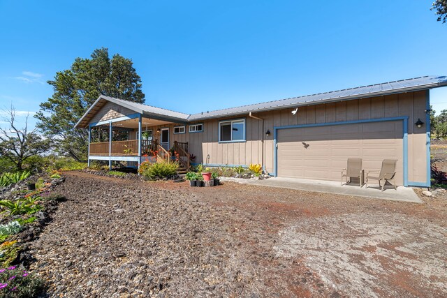 ranch-style home featuring covered porch and a garage