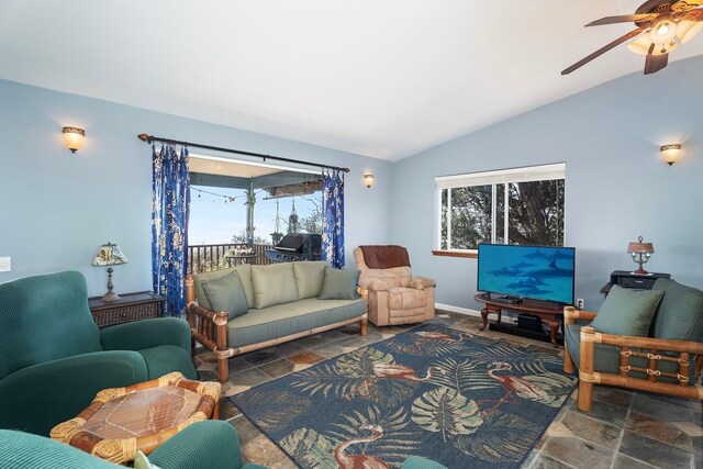 living room featuring ceiling fan and lofted ceiling