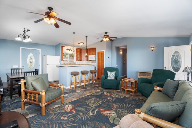 living room featuring ceiling fan with notable chandelier and lofted ceiling