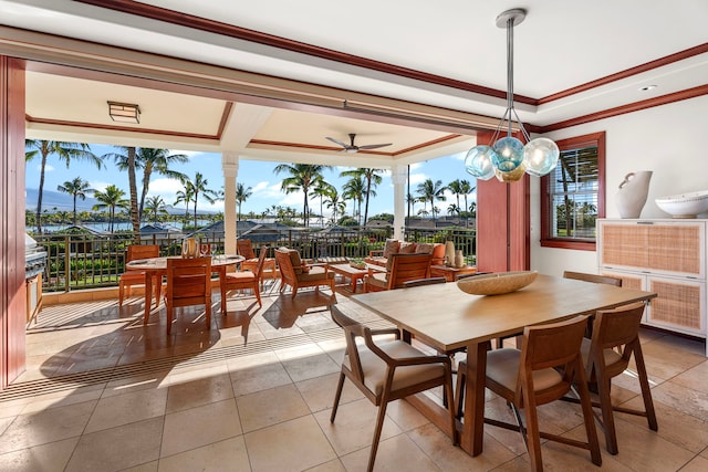 tiled dining space featuring ceiling fan, a wealth of natural light, a tray ceiling, and crown molding