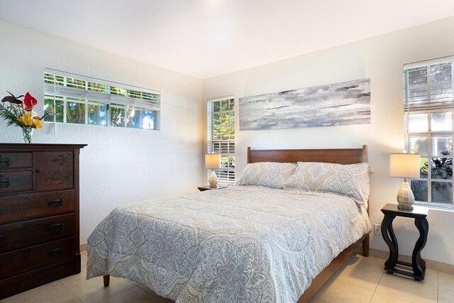 bedroom featuring multiple windows and light tile patterned flooring