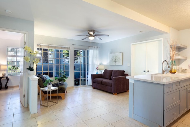 living room featuring ceiling fan, sink, and light tile patterned floors