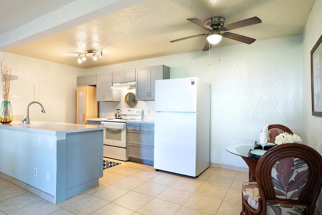 kitchen with sink, a textured ceiling, light tile patterned floors, gray cabinets, and white appliances