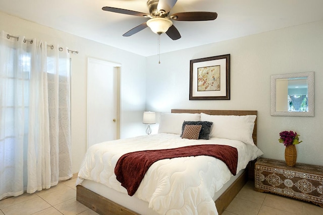 tiled bedroom featuring ceiling fan and multiple windows