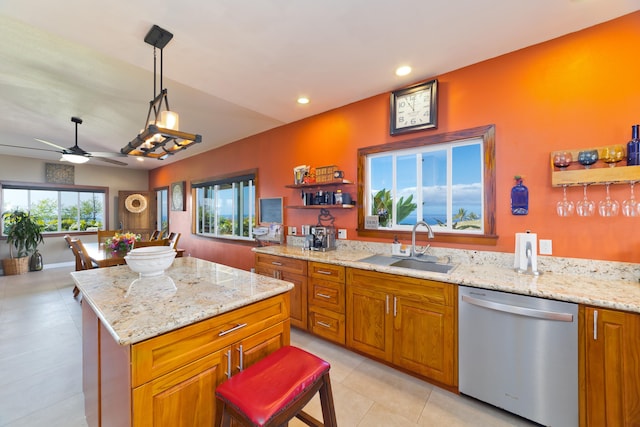 kitchen featuring dishwasher, sink, ceiling fan, decorative light fixtures, and a kitchen island