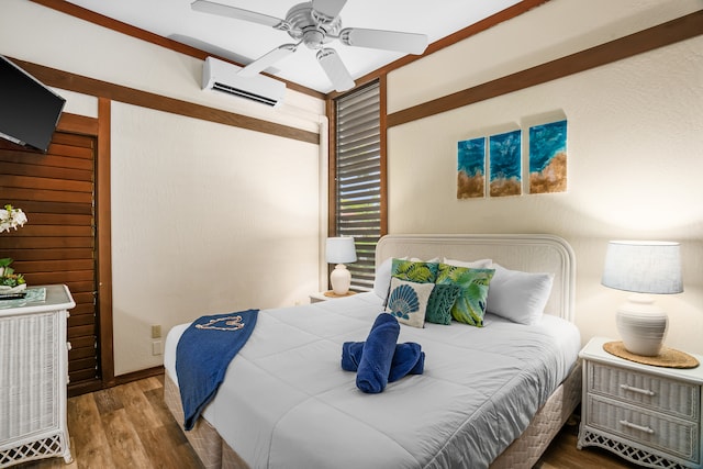 bedroom featuring hardwood / wood-style floors, a wall unit AC, and ceiling fan