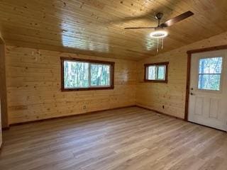 bonus room featuring wood walls, lofted ceiling, ceiling fan, light hardwood / wood-style floors, and wood ceiling