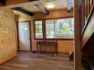 misc room with dark hardwood / wood-style floors, wood walls, and beam ceiling