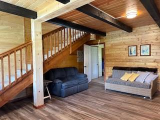 living room featuring beamed ceiling, wooden ceiling, and wood-type flooring