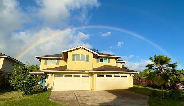 view of front of home with a front yard and a garage