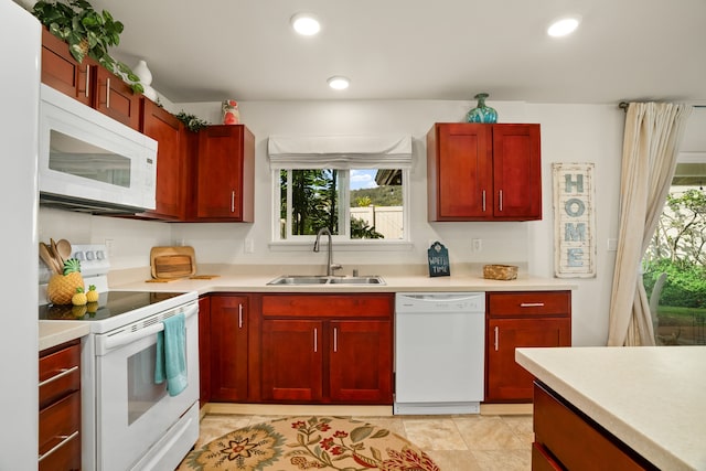 kitchen with light tile patterned floors, white appliances, and sink