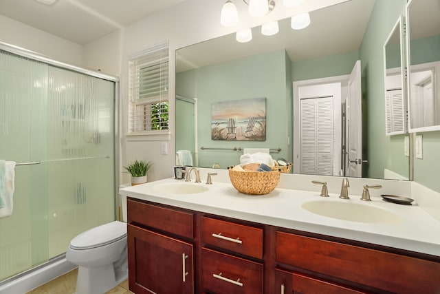 bathroom with tile patterned flooring, vanity, toilet, and an enclosed shower