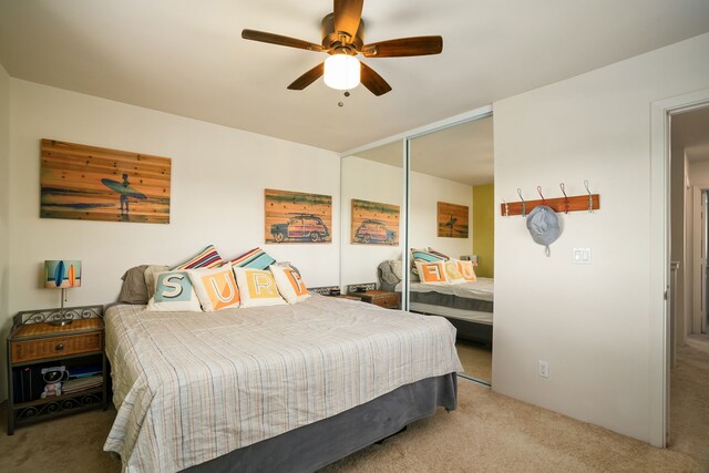 bedroom featuring ceiling fan, a closet, and light carpet