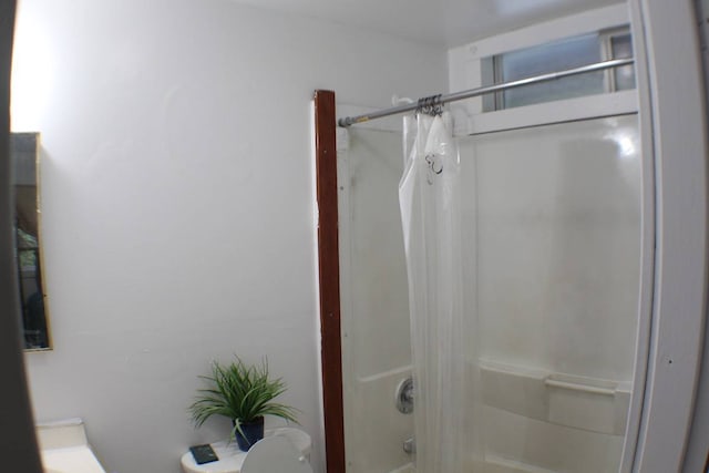 bathroom with shower / bath combination with curtain and toilet