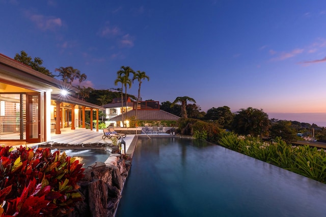 pool at dusk with a patio area