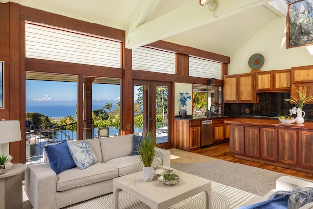 living room with beam ceiling, a water view, dark hardwood / wood-style floors, and high vaulted ceiling