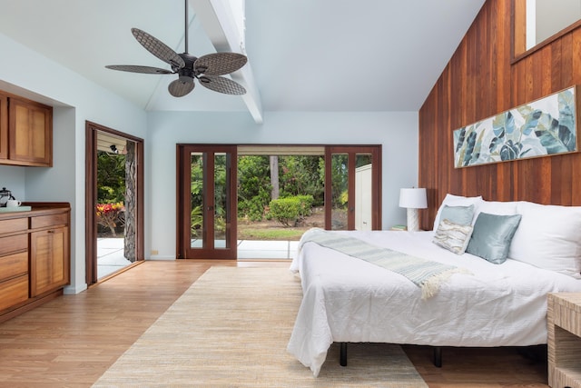 bedroom featuring access to outside, ceiling fan, lofted ceiling with beams, light hardwood / wood-style flooring, and wood walls