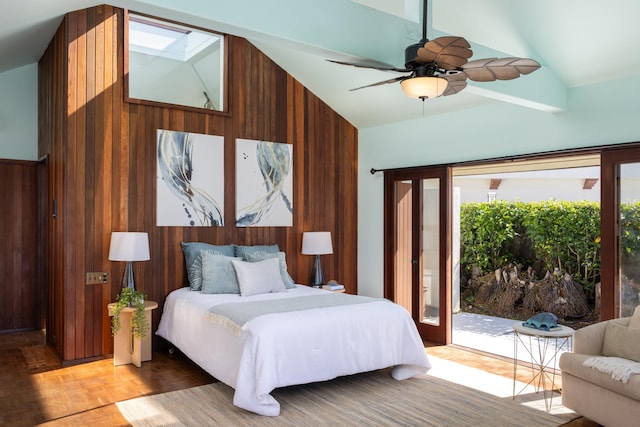 bedroom with ceiling fan, lofted ceiling, access to outside, wooden walls, and light parquet flooring