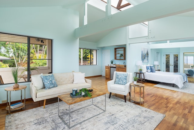 living room featuring wood-type flooring, high vaulted ceiling, and a wealth of natural light