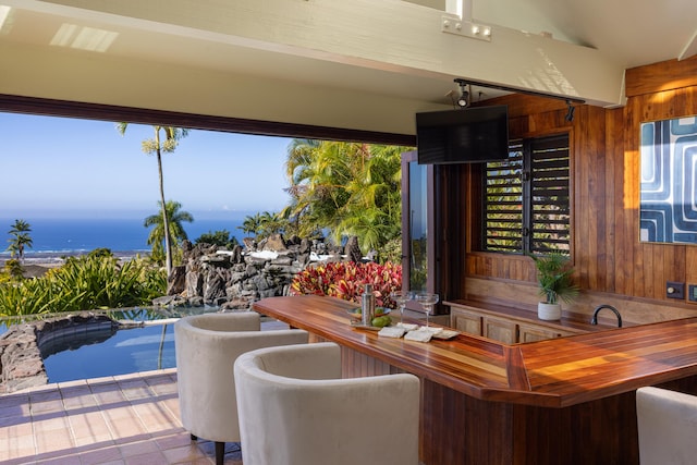 interior space featuring a water view, an outdoor bar, and a pool