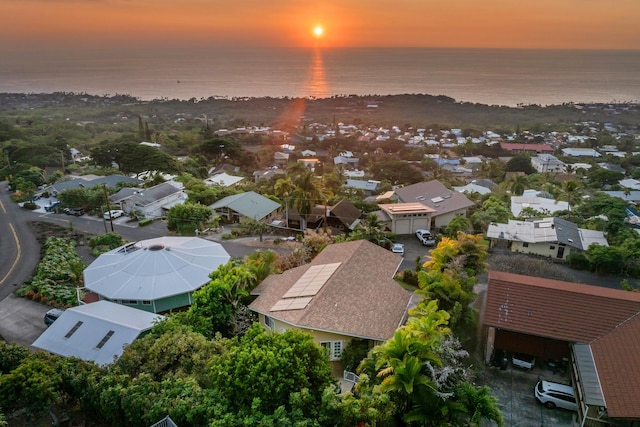 aerial view at dusk featuring a water view