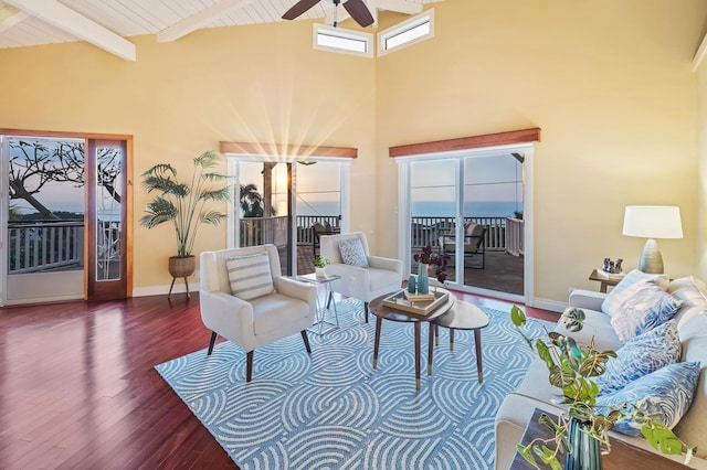 living room featuring ceiling fan, beamed ceiling, and dark hardwood / wood-style floors