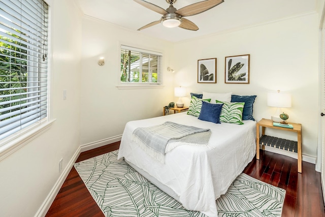 bedroom featuring dark hardwood / wood-style flooring, ceiling fan, and ornamental molding