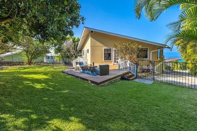 back of house with a lawn, an outdoor living space, and a wooden deck