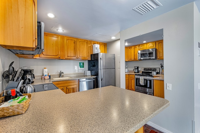 kitchen featuring kitchen peninsula, sink, and appliances with stainless steel finishes