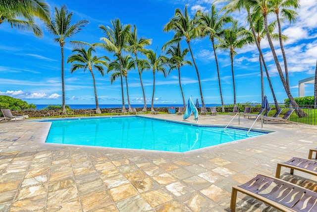 view of pool featuring a patio area and a water view