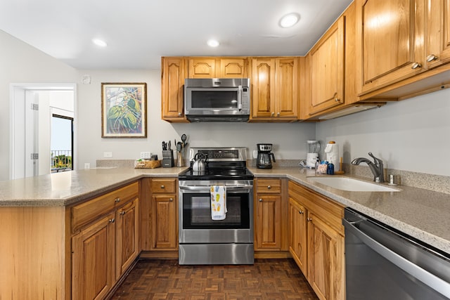 kitchen with kitchen peninsula, appliances with stainless steel finishes, dark parquet floors, and sink