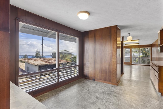 dining space with a textured ceiling and wood walls