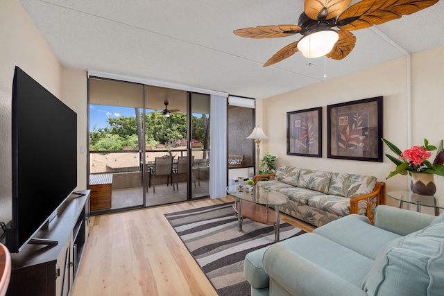 living room with expansive windows, a textured ceiling, and light hardwood / wood-style flooring