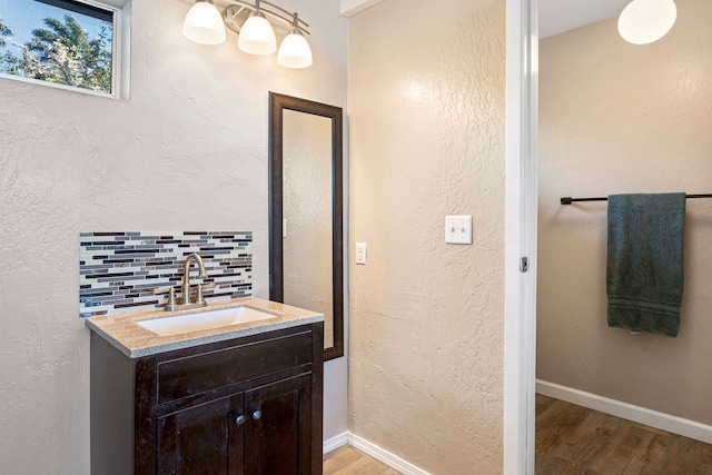 bathroom featuring decorative backsplash, vanity, and hardwood / wood-style flooring