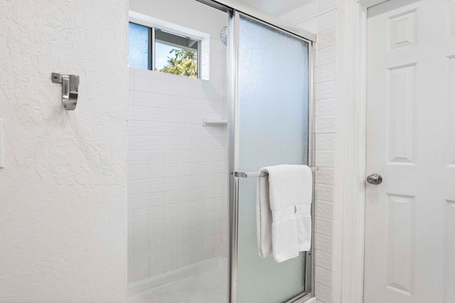 bathroom with a shower with door